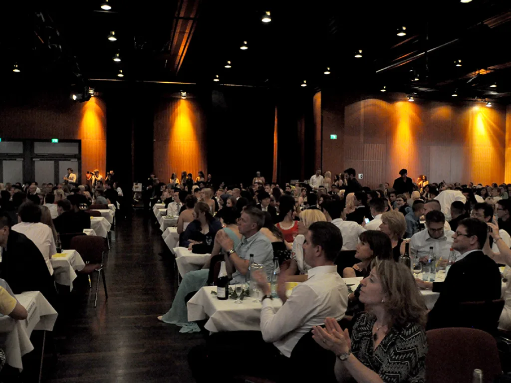 Gäste sitzen an den Tischen im Saal.